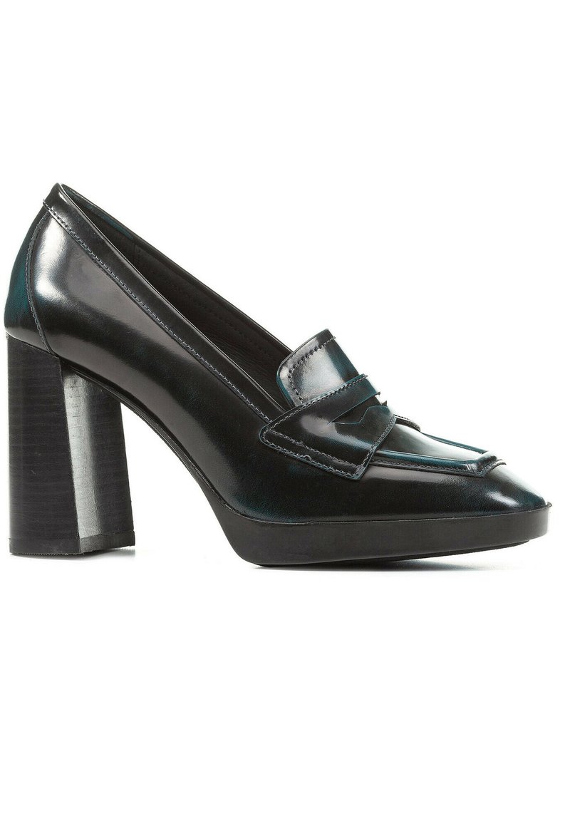 Mocasines de charol negro de tacón alto con punta redonda, tirante decorativo y un tacón ancho. Textura suave con un acabado brillante.
