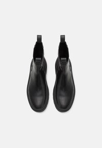 Schwarze Lederstiefeletten mit glatter Oberfläche, elastischen seitlichen Einsätzen und Zuglaschen. Runde Zehenform und dicke Gummisohlen.