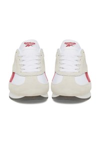 Reebok tenisky so zmesou bielej kože a sivej semišovej látky, so červenými akcentmi, okrúhlou špičkou a šnúrkami. Mäkko štruktúrovaný vrch. Plochá podrážka.