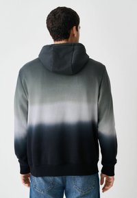 Hanorac cu glugă cu un design ombre, care trece de la gri deschis la negru; realizat dintr-un material moale, cu manșete și tiv din material texturat.