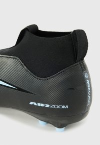 Crampons de football noirs avec une tige synthétique texturée et un cuff de cheville élastique. Présente des accents bleu clair et une semelle arrondie avec plusieurs crampons.