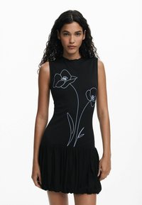 Rochie neagră fără mâneci, cu o parte superioară ajustată și o fustă evazată, decorată cu broderie florală albă pe față și un decolteu cu margini ondule.