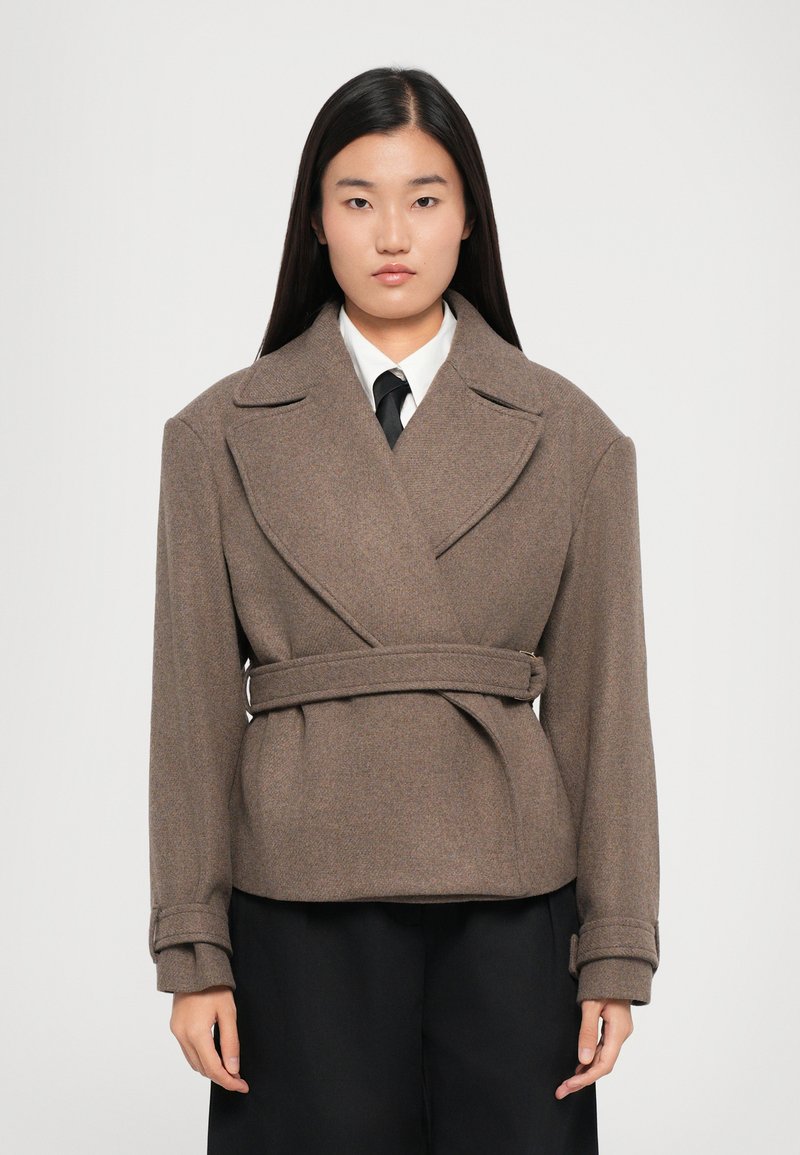 Brown wool blend wrap jacket with oversized lapels, a belted waist, and long sleeves, featuring textured fabric and clean lines.