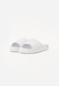 White slide sandals made of textured material, featuring an open toe and a simple design with three horizontal stripes across the upper.