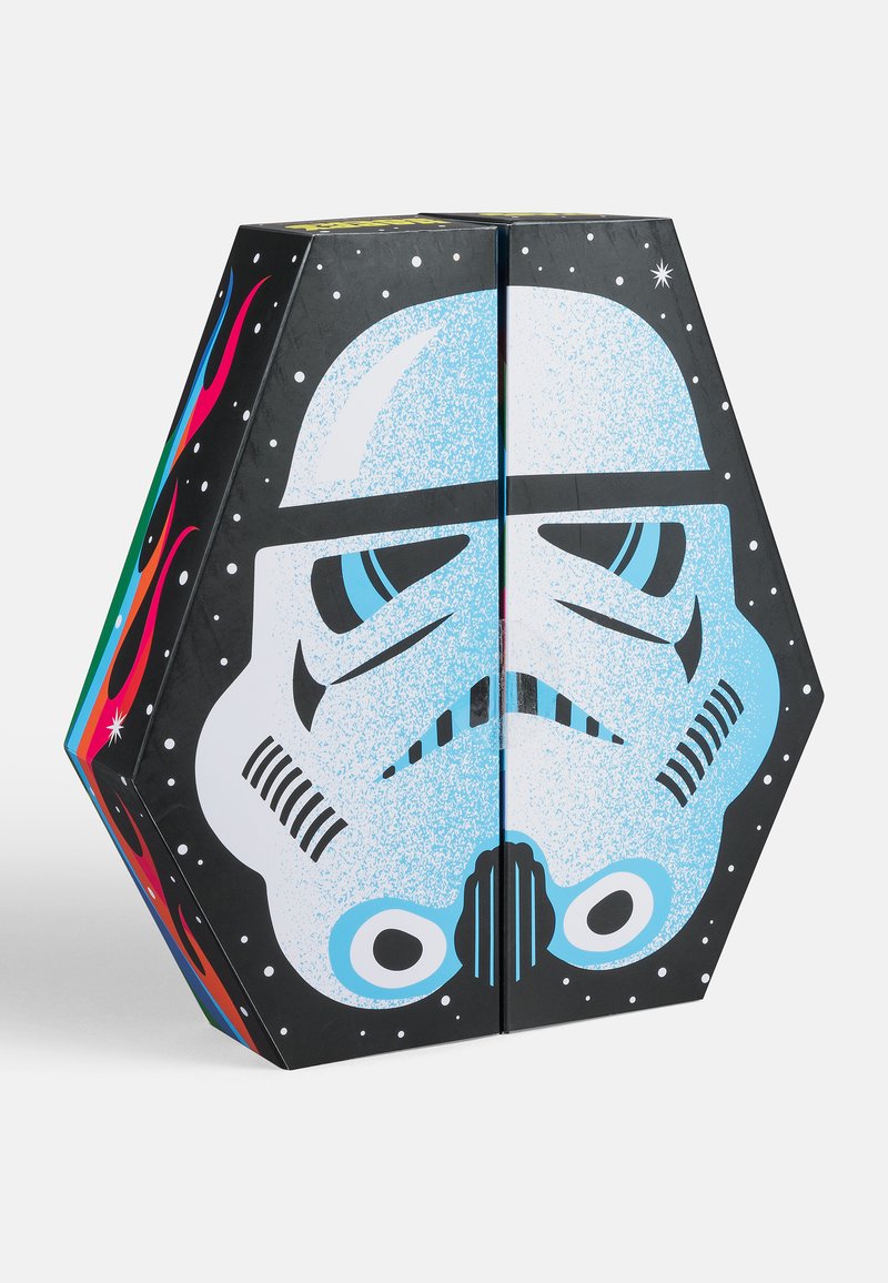 Sechskantige Pappschachtel mit einem Design eines Stormtrooper-Helms. Hauptfarben: Schwarz, Weiß und Blau. Texturierte Details und farbenfrohe Akzente.