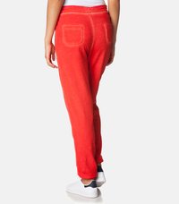 Rde flis jogger hlače z elastiko v pasu, dvema zadnjima žepoma in zoženimi nogami. Ujemajo se z belimi supergami z mornarsko modrimi detajli.