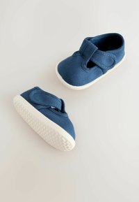 Paire de petites chaussures bleues pour tout-petits avec semelles en caoutchouc blanches et bandes velcro sur fond clair.