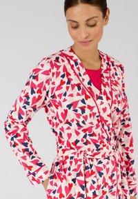 Roze badjas met een hartprint in tinten van rood en marineblauw, met lange mouwen, een riem en een sjaalkraag. Zachte stofstructuur.