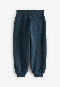 Marineblauwe sweatpants met een taps toelopend ontwerp, elastische tailleband en geribde boorden. Heeft een enkele achterzak zonder zichtbare patronen.