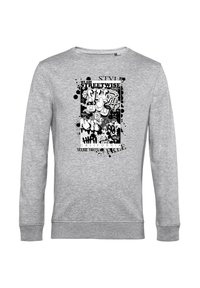 Šedá dlouhá trička s černobílým grafickým designem ve stylu graffiti, obsahující kreslené obličeje, text "STREETWISE" a vzorová nátěrová skvrna.