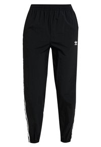 Černé tepláky vyrobené z lehkého materiálu, s elastickým pasem, zúženými nohavicemi a bílými bočními pruhy s logem Adidas.