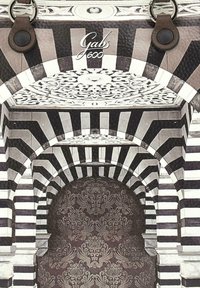 Arco a strisce bianche e nere con un ornate motivo floreale sul soffitto e tessuto damascato testurizzato visibile attraverso l'apertura dell'arco.