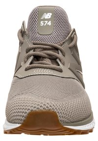New Balance 574 sneakers i gråbrun mesh med gummisula, med snörning, logotyp patch och subtila detaljer på det övre designet.