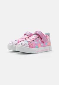 Rosa sneakers med stjärnmönster, dekorerade med nitar på tån, med en kardborrerem och en gummisula. Glittriga accenter ingår.