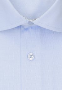 Lichtblauwe gekraagde shirt met een subtiele diagonale textuur. Heeft een knoopsluiting bij de hals en een nette, gestreken uitstraling.