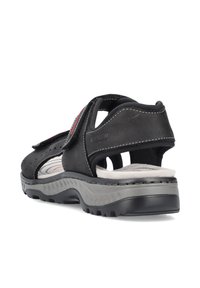 Sandales en daim noir avec une semelle en caoutchouc gris, dotées de brides ajustables, d'un design perforé et d'accents de couture gris.