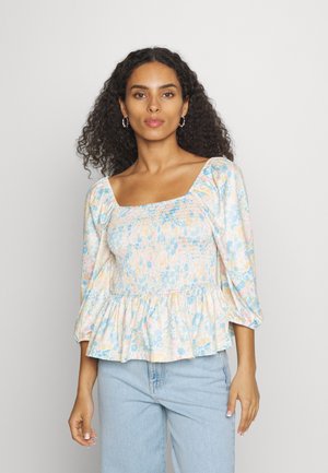 Blusa peplum floral em cores pastel, com decote quadrado, corpete franzido e mangas bufantes. Feita de um tecido leve.
