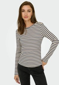 Marineblauwe en crèmekleurige gestreepte langemouwtop met geribbeld textuur en schouderknoppen, gecombineerd met zwarte slim-fit broek.