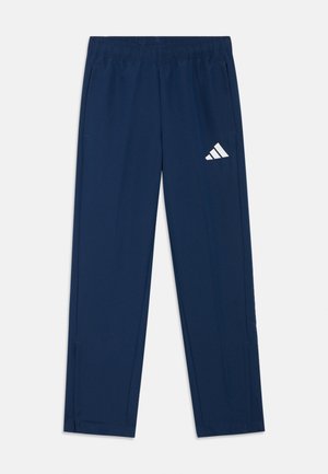 Pantalon de sport bleu marine en tissu léger, avec une ceinture élastique, des poches latérales et un logo Adidas blanc sur la cuisse gauche.