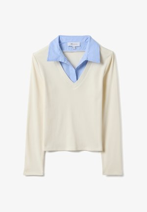 Jersey de manga larga con cuello en V; cuenta con cuerpo acanalado de color crema y cuello a rayas azules con capa interna.