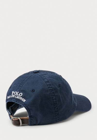 Tamsiai mėlynas medvilninis kepurė su reguliuojama odine juosta, išsiuvinėtas "POLO RALPH LAUREN" raštas gale, minkšta tekstūra, išlenktas skydelis.