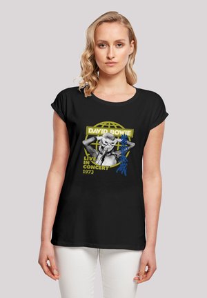 Black short-sleeve t-shirt featuring a graphic of a singer, text reading "David Bowie Live in Concert 1973," with yellow and blue accents.