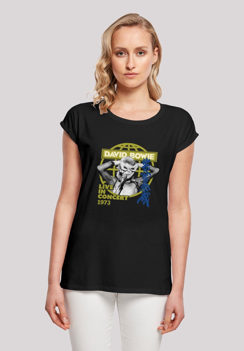 Schwarzes T-Shirt mit kurzen Ärmeln, das ein Grafik eines Sängers zeigt, mit dem Text "David Bowie Live in Concert 1973" und gelben sowie blauen Akzenten.
