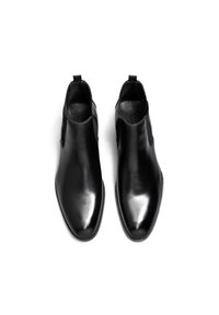 Stivali neri in pelle alla caviglia con pannelli elastici laterali, design elegante, punta affilata e finitura liscia; minimalismo nei dettagli e assenza di hardware visibile.