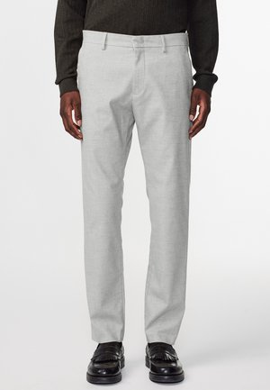 Hellegraue maßgeschneiderte Hose mit glatter Textur, geradem Schnitt, Gürtelschlaufen und seitlichen Taschen, kombiniert mit schwarzen Lederschuhen.