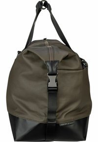 Duffelväska i olivgrön tyg med en svart botten. Har en dragkedjestängning, svarta läderdetaljer och justerbara remmar.