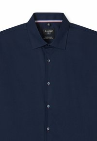 Chemise habillée pour homme coupe slim de couleur bleu marine avec col évasé et quatre boutons sur le devant, avec des détails d'étiquette à l'intérieur du col.