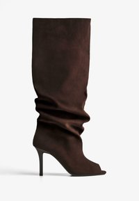 Tmavo hnedé semišové čižmy po kolená so sklopeným nátepnikom, otvorenou špičkou a štíhlým ihlovým podpätkom na bielom pozadí.