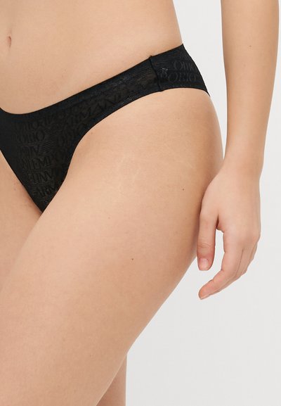 Tanga negro hecho de una tela texturizada, con un patrón repetitivo del nombre de la marca y un diseño de cintura baja.