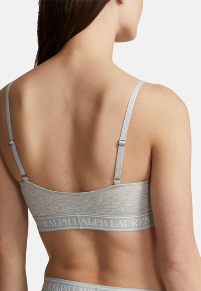 Bralette de algodón gris con una textura suave, tirantes ajustables y una banda ancha con un logotipo en un color contrastante. Vista trasera.