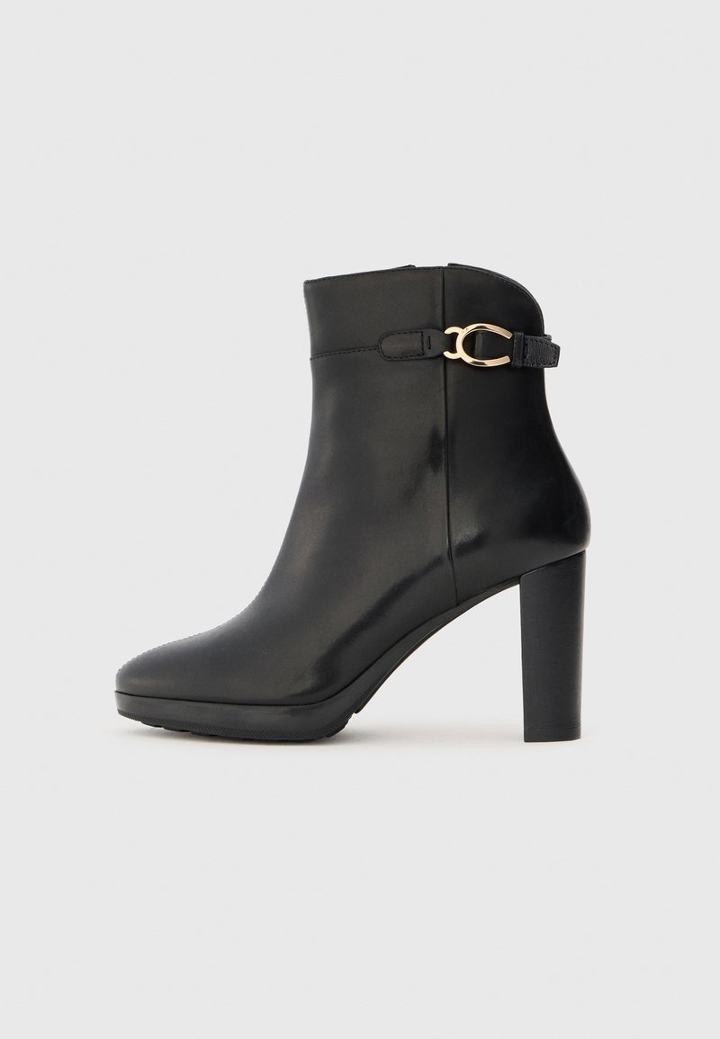 Bottine en cuir noir avec un bout pointu, un talon aiguille haut et un accent de boucle dorée sur le côté. Texture lisse et design épuré.
