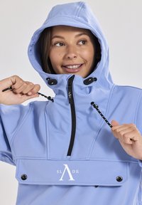 Helle blaue wasserdichte Jacke mit Kapuze. Verfügt über einen Frontreißverschluss und verstellbare Kordeln. Markenlogo "SLADE" auf der Brust.