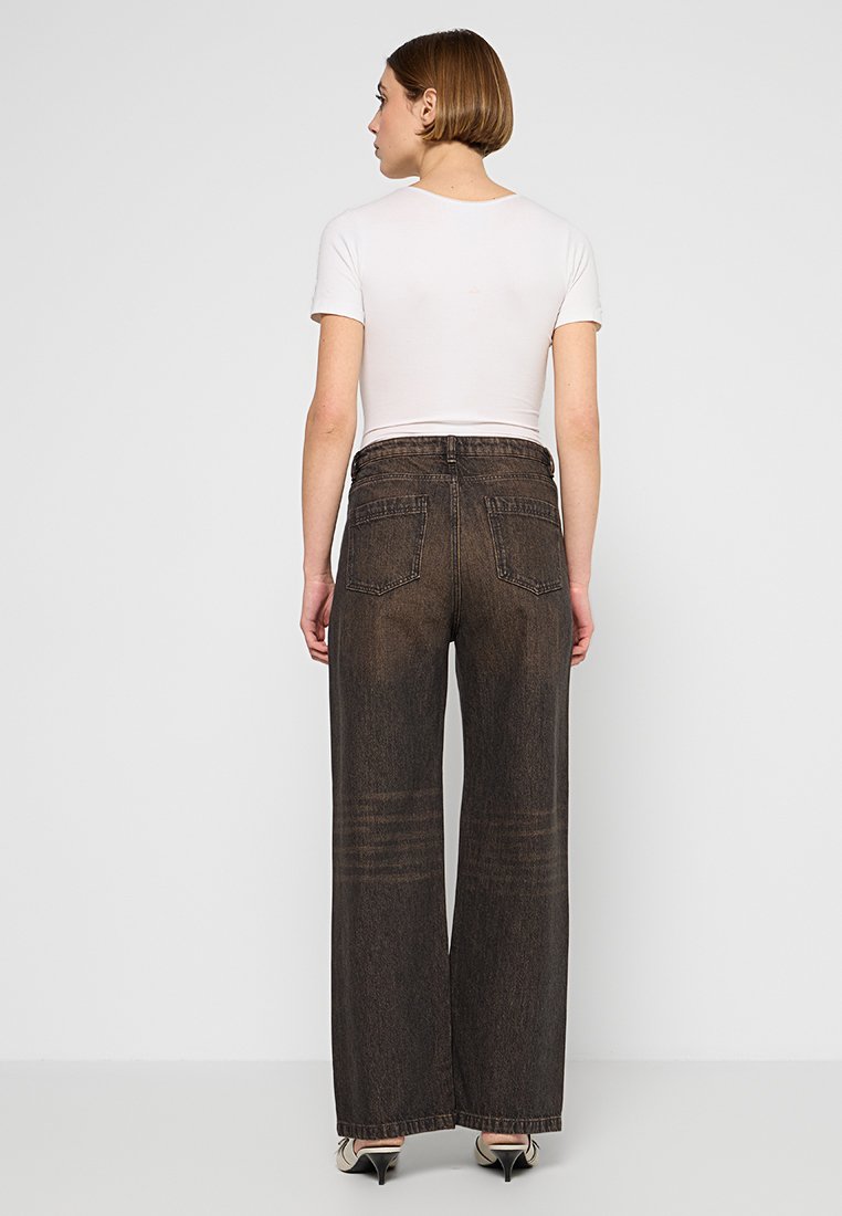 Dunkelblaue, weit geschnittene Jeans aus Denim mit einer verblassten Waschung, hohe Taille, fünf Taschen und genähten Details entlang der Beine.