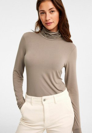 Långärmad polo-top i taupe jersey-tyg, med en rynkad halsringning. Matchas med ribbad krämfärgad kordflöjtbyxor.