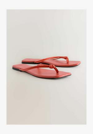 Plokščios raudonos šlepetės, pagamintos iš lygaus materiālo, su unikaliu rištų dirželiu dizainu ir minimalistiškomis juodomis padangomis kontrastui.