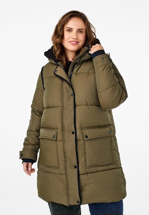 Manteau matelassé vert olive avec capuche, doté d'une fermeture éclair et de boutons-pression, de deux poches avant et d'un bord noir le long des contours. Tissu texturé.