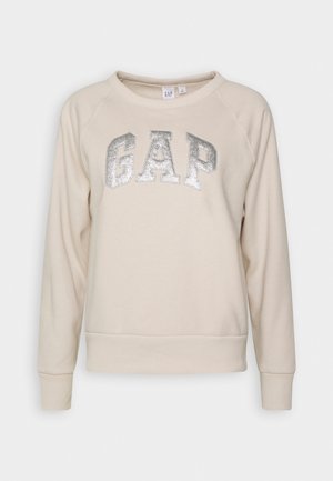 Sweat-shirt à manches longues couleur crème avec logo « GAP » pailleté argenté sur la poitrine, col rond, poignets et ourlet côtelés.