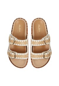 Two strap sandals featuring a cream woven upper with decorative stitches, adjustable metal buckles, and a brown sole with stud accents.
