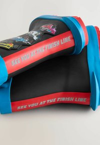 Bottes de pluie en caoutchouc avec une base noire, des accents bleus et des rayures rouges. Présente des graphismes de voitures de course et le texte "ON SE RETROUVE À LA LIGNE D'ARRIVÉE."