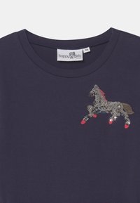 Navy cotton t-shirt featuring a sequined horse design with red accents on hooves and mane. Rounded neckline and short sleeves.