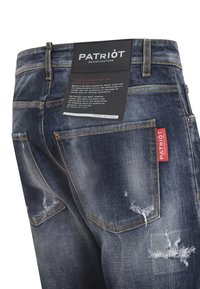 Jeans in denim blu scuro con dettagli consumati, etichetta del marchio visibile e cuciture gialle sulle tasche. Progettati con un taglio dritto.