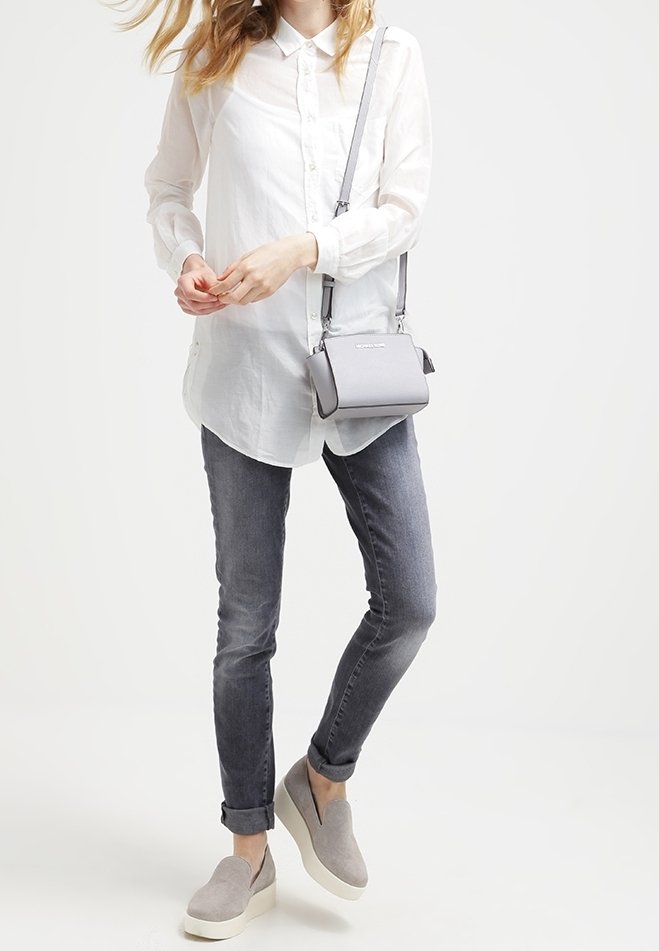 Valkoinen nappikauluspaita, harmaat farkut, harmaat liukusandaalit valkoisilla vaihteilla sekä pieni harmaa olkalaukku. Yksinkertainen, puhdas muotoilu ilman näkyviä kuvioita.