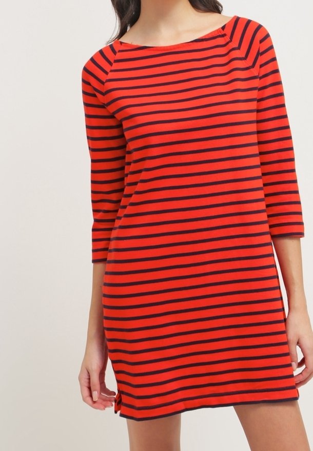 Robe rayée rouge et marine avec des manches trois-quarts, un col bateau et des fentes latérales. Fabriquée en tissu doux et léger.