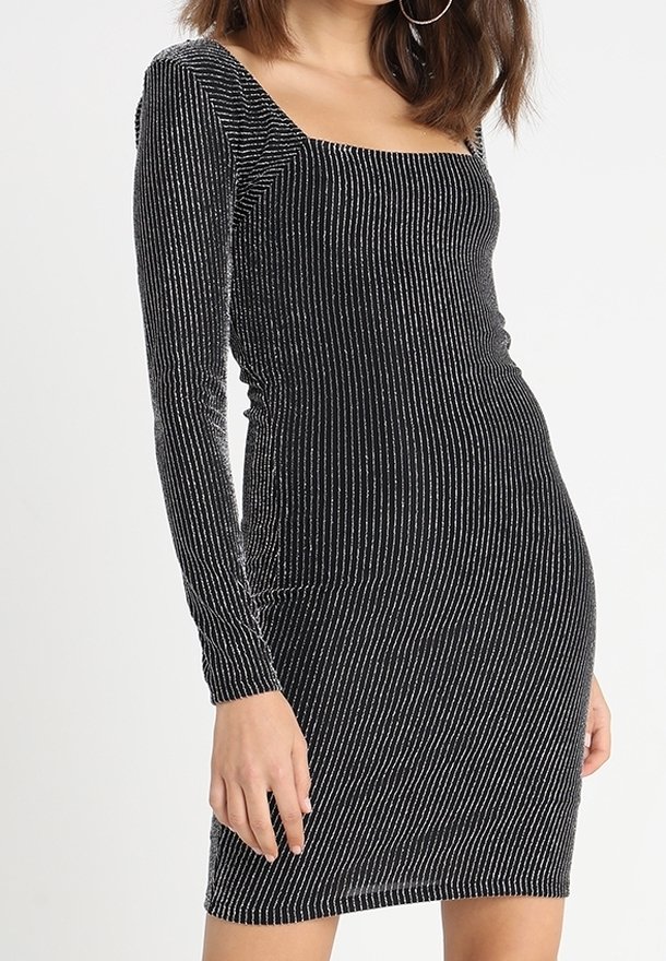 Zwart langshirt met een vierkante halslijn. Kenmerkt zich door een geribbelde textuur en zilveren verticale strepen voor een glinsterend effect. Bodycon pasvorm.
