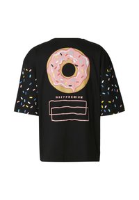 Černé tričko s krátkým rukávem s velkým růžovým obrázkem donutu na zádech a barevnými posypy na rukávech.