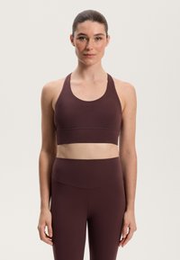 Mörkröd sportbehå med breda remmar och en sydd band, i kombination med matchande högmidjade leggings, slät tyg, figursydd design.